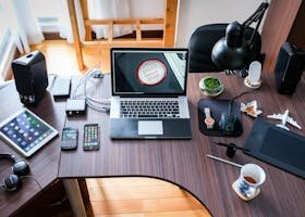 A contemporary office desk setup with laptops, gadgets, and accessories, creating a tech-savvy workplace.